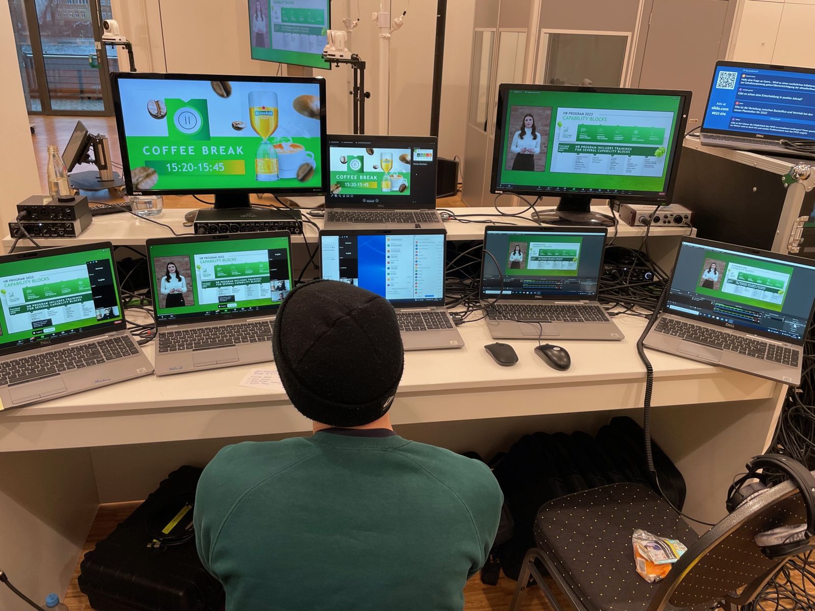 Production control desk with monitors for broadcasting a hybrid event