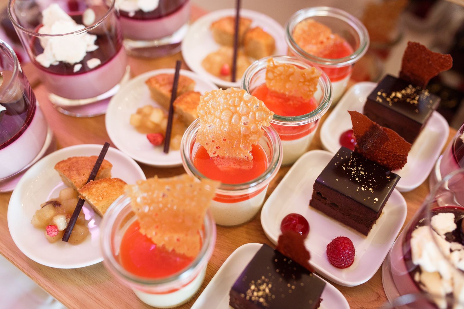 Desserts in glasses and small cakes on the buffet